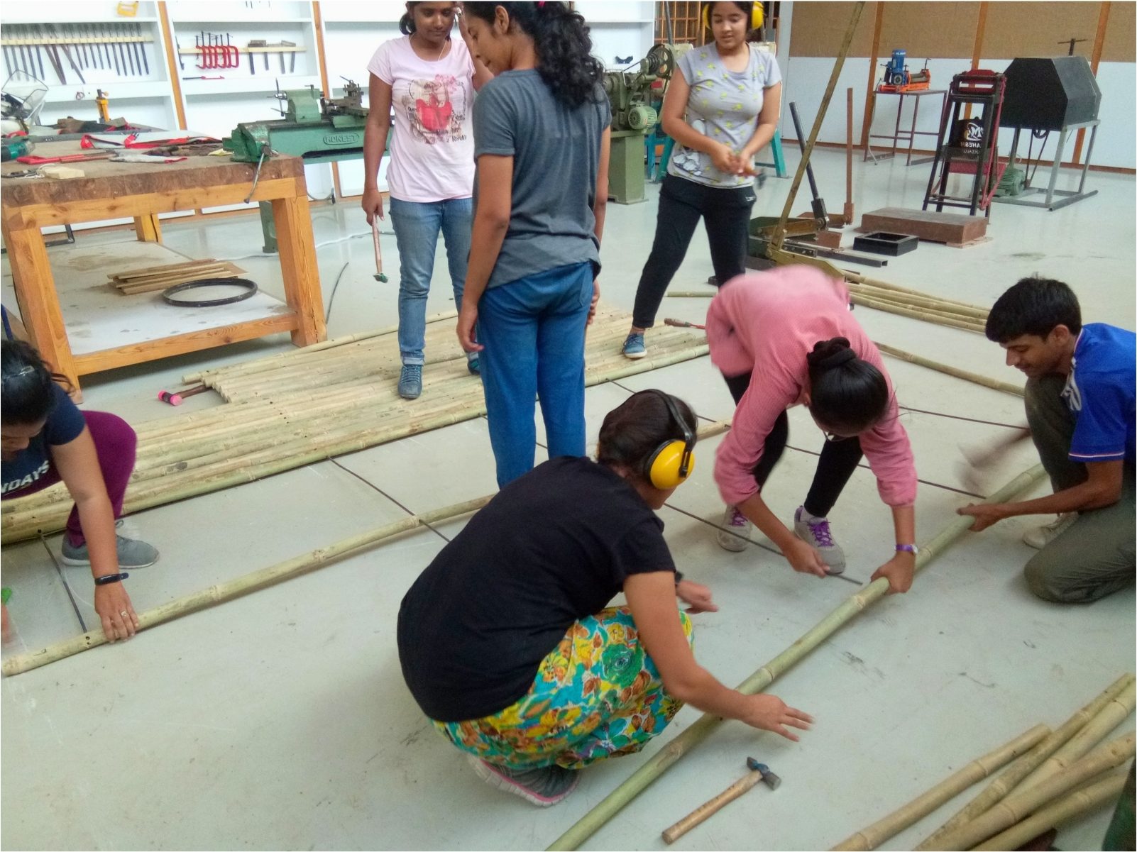 Bamboo poles cleaned and cut to one length on the workshop floor.
