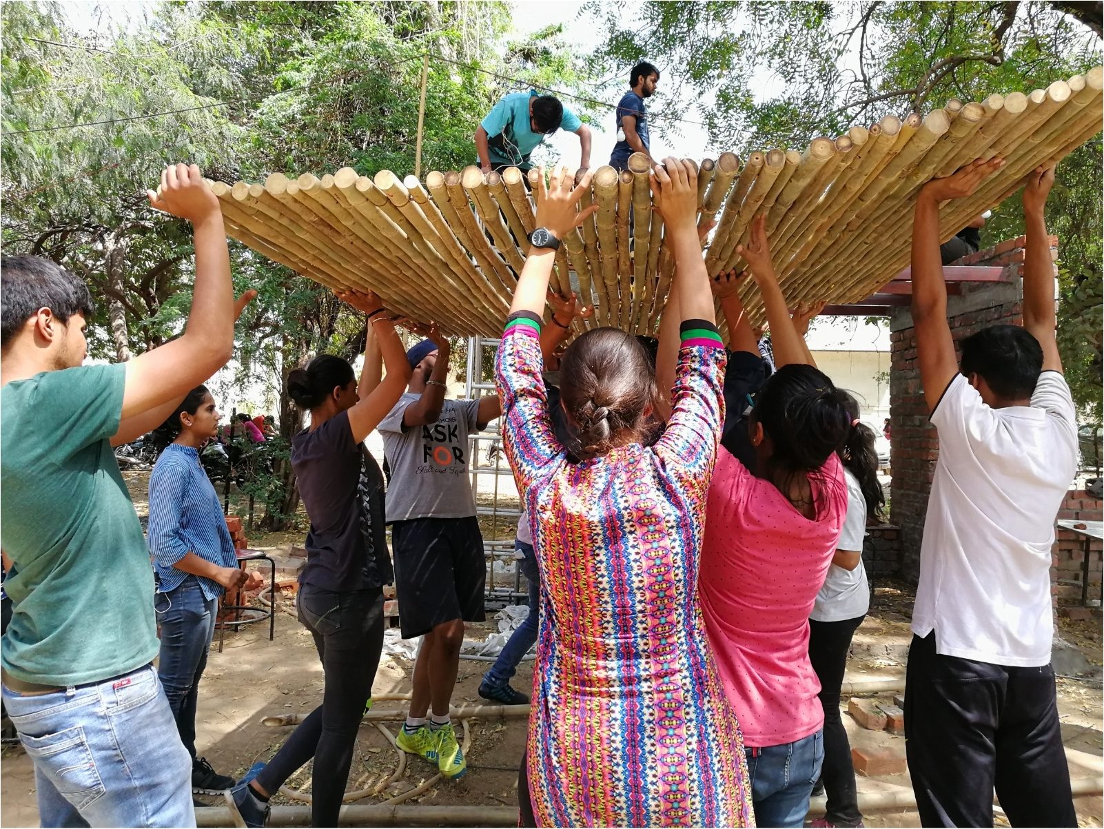 The bamboo roof frame, made flat on the ground and carried in whole. The drawing showed it arriving, not how.