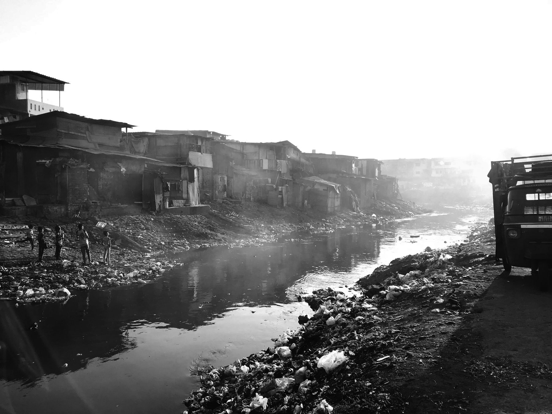 The creek. The settlement's edge, its dump and its washing ground at once.